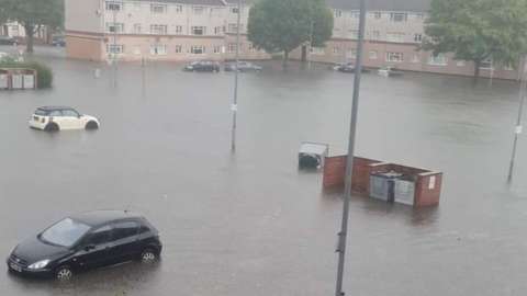 Flooding around cars parked outside flats on Sandy Lane