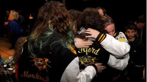 Students hug during a vigil to honour the victims of Tuesday's shooting at Oxford High School in Oakland County, Michigan