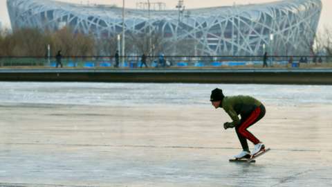 A man skates on a frozen canal at Beijing Olympic Park