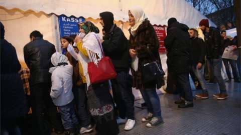 Migrants and refugees wait in the early hours outside Berlin's Central Registration Office for Asylum Seekers of the State Office for Health and Social Services on 9 December 2015