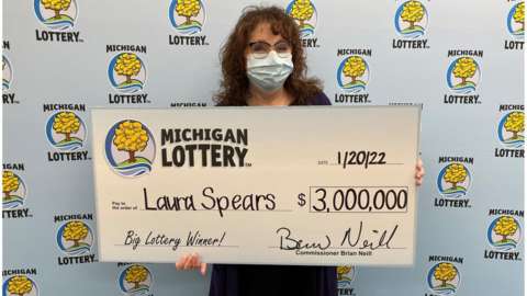 Laura Spears holding a giant cheque