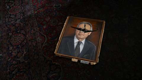 A vandalized painting depicting a political figure lies on a room at the National Congress