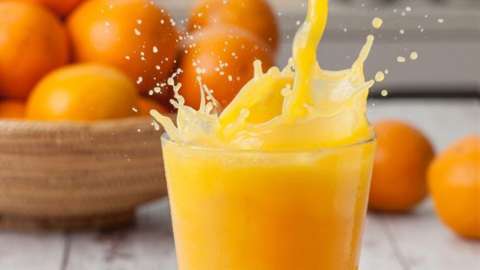 Splashing orange juice on table