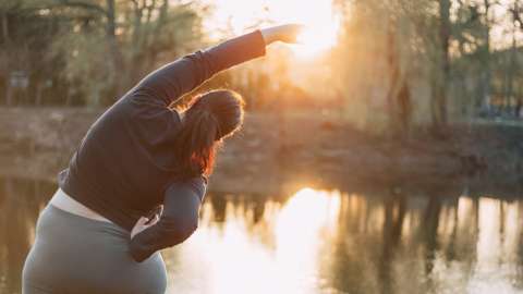Woman stretching by a lake