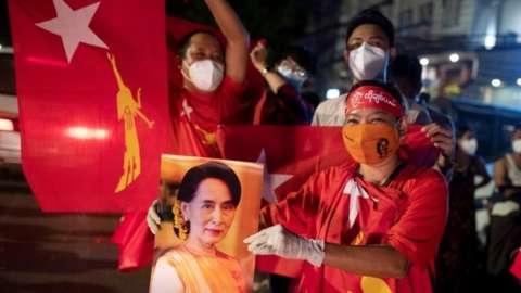 A supporter of Aung San Suu Kyi holds a sign with her picture