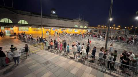 Fans queue outside Cardiff Central railway station after the show