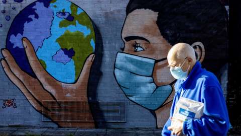 A pedestrian on the Taff Trails passing the street art painted Thomas Llewelyn