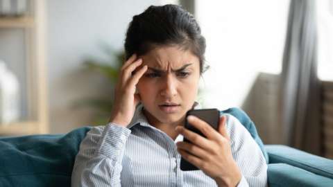 A young woman concerned by something on her phone