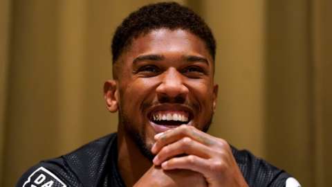 Anthony Joshua smile as he answers questions