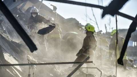 Firefighters clean the rubble of the destroyed Amstor shopping mall in Kremenchuk, Poltava Oblast, Ukraine, 28 June 2022
