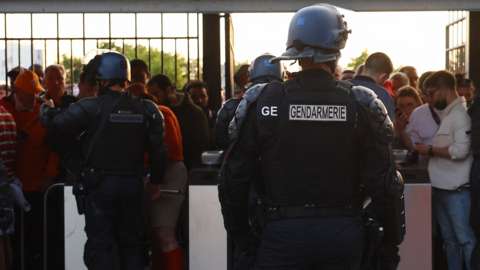 Police officers with fans by the turnstiles at the Stade de France
