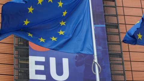 An EU flag flutters outside the European Commission headquarters in Brussels. Photo: 15 October 2020