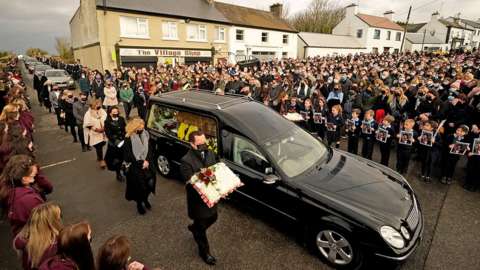 Mourners walk beside the hearse as the cortege arrives at St Brigid's Church, Mountbolus, Co Offaly, Ireland, for the funeral of Ashling Murphy, on 18 January 2022
