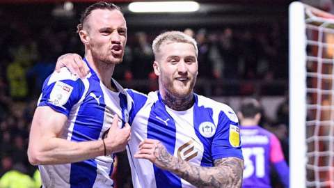 Will Keane celebrates Wigan's second goal at Crewe