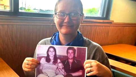 Holly Crouse holds a photo of her murdered parents