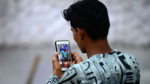 In this photograph taken on October 14, 2018, an Indian man edits a photo on his smartphone in Allahabad