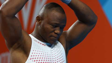 Former refugee Cyrille Tchatchet II's dream of a Commonwealth Games medal for England was ended by cramps in the men's 96kg weightlifting final.