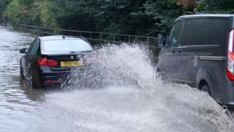 Car and van driving through flood