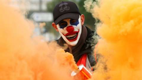 A protester wearing a mask is seen amongst smoke as French Labour unions demonstrate against the government's pensions reform plans, 5 December 2019