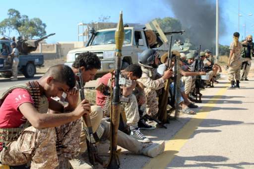 Soldiers from forces aligned with Libya's new unity government resting on the road during an advance on the Islamic State stronghold of Sirte