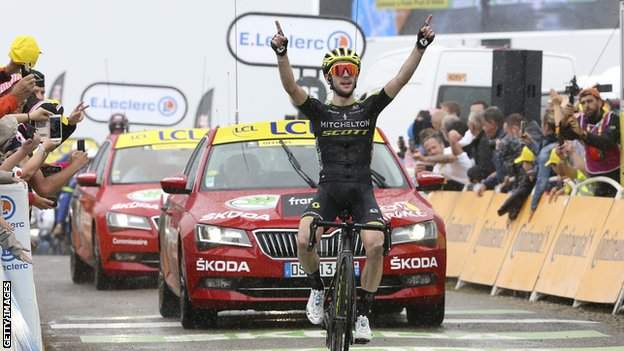 Simon Yates raises his hands in celebration after winning a stage of the 2019 Tour de France