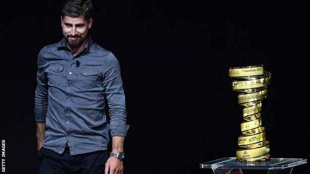 Cyclist Peter Sagan stands next to the Giro d'Italia trophy at the route presentation