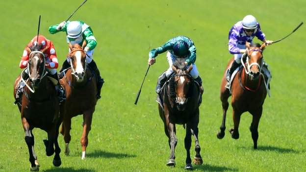 Jockeys using whips during a race