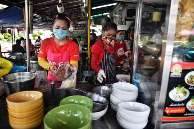 Staff prepare dishes at a noodle restaurant in Bangkok on May 3, 2020
