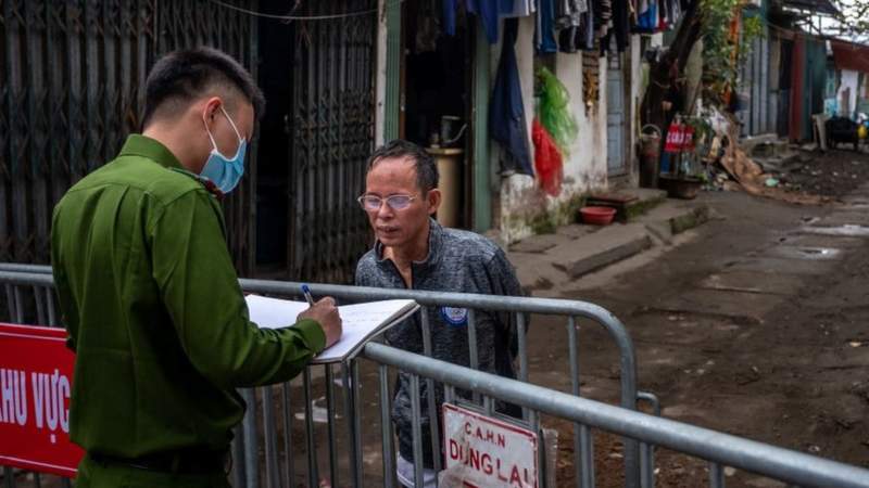 Cảnh sát kiểm tra danh tính một cư dân sống trong khu cách ly ở quận Cầu Giấy, Hà Nội