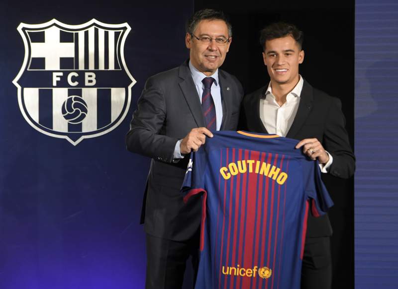 Philippe Coutinho poses with a Barcelona shirt alongside club president Josep Bartomeu.