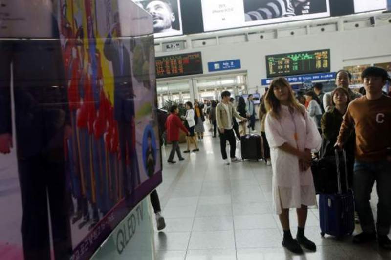 Hành khách xem trên màn hình lớn ở ga xe lửa Seoul