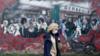 Женщина проходит мимо настенной росписи во время вспышки коронавируса в Голуэе, Ирландия