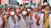 Врачи больницы Раджавади делают знак победы, ожидая начала кампании по вакцинации против коронавируса Covid-19 в Мумбаи 16 января 2021 года.
