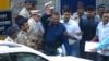 Индийский болливудский актер Санджай Датт (С) машет рукой, когда его сопровождают официальные лица из тюрьмы Йервада в Пуне 25 февраля 2016 года.