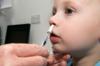 Мальчику вводят вакцину против гриппа в виде назального спрея