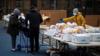Женщина организует еду, подаренную Центром распределения продуктов питания на мобильном рынке City Harvest, во время вспышки коронавирусной болезни (COVID-19) в Бруклинском районе Нью-Йорка, США, 15 апреля 2020 г.