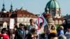 Протестующие в Праге держат антиисламский плакат и плакат против обязательных квот ЕС на прием беженцев