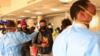 Пассажиры в масках стоят в очереди на досмотр после прибытия из Китая в международный аэропорт Джомо Кеньятта