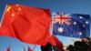 Протестующие в Канберре несут флаги Китая и Австралии