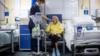Сотрудник реабилитационной службы осматривает 86-летнюю Ширли Хьюз, когда первые пациенты поступают в NHS Seacole