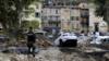 Жандарм стоит среди обломков, включая машины, в Брей-сюр-Ройя, юго-восток Франции