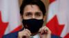 Премьер-министр Канады Джастин Трюдо надевает маску на пресс-конференции, посвященной обсуждению коронавирусной болезни в стране