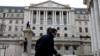 Мужчина в защитной маске проходит мимо Банка Англии в лондонском Сити