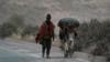 Фермер и его осел идут по дороге, покрытой пеплом, выброшенным вулканом Сангай, в Алауси, провинция Чимборасо, Эквадор, 20 сентября 2020 г.