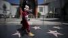 Артист в костюме Микки Мауса перед закрытым театром TLC Theatre на почти пустом Голливудском бульваре