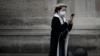 Женщина в маске проверяет свой телефон, Париж, 31 января 2020 г.