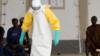 Медицинский работник в защитном костюме лечит пациентов с Эболой в Западной Африке