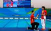 Хэ Цзи (справа) из Китая получает предложение руки и сердца от китайского ныряльщика Ки Циня (слева) после того, как выиграл серебряную медаль в финале трехметрового трамплина среди женщин на Олимпийских играх в Рио-2016