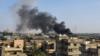 Дымовые шлейфы выходят из зданий после авиаудара по Таджура, к югу от Триполи, 29 июня