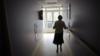 Женщина, страдающая болезнью Альцгеймера, идет по коридору в доме престарелых в Анжервилье, восточная Франция (фотография из файла 2011 г.)